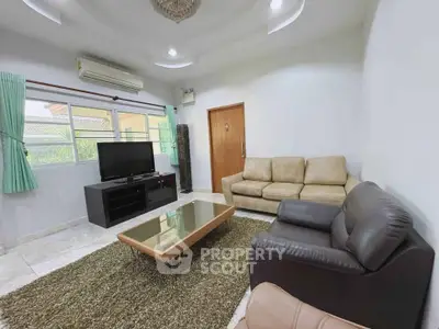 Spacious living room with modern furniture and large windows offering natural light.