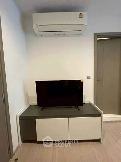 Modern living room with sleek TV stand and air conditioning unit, perfect for comfortable living.