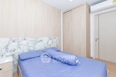 Modern bedroom with stylish marble accent wall and cozy blue bedding