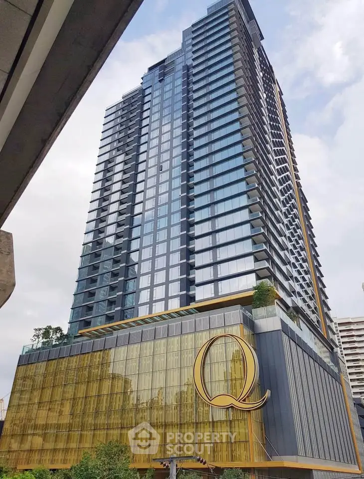 Stunning modern high-rise building with sleek glass facade and luxurious design in urban setting.