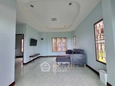 Spacious living room with modern furniture and large windows in a stylish home.