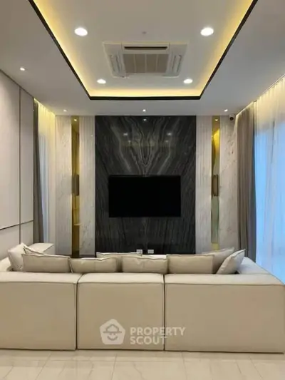 Luxurious modern living room with elegant marble accent wall and plush beige sofa.
