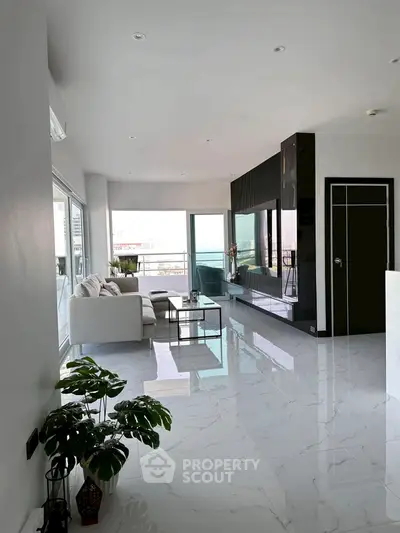 Luxurious modern living room with sleek marble flooring and stunning balcony view.