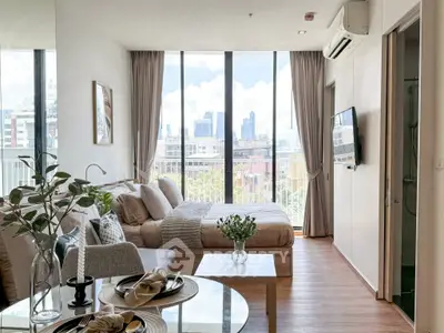Modern studio apartment with city view, featuring cozy living area and elegant dining setup.
