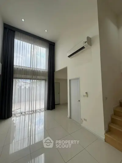 Spacious modern living room with high ceilings and large windows