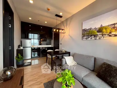 Modern living room with open kitchen, stylish decor, and cozy seating area in a contemporary apartment.