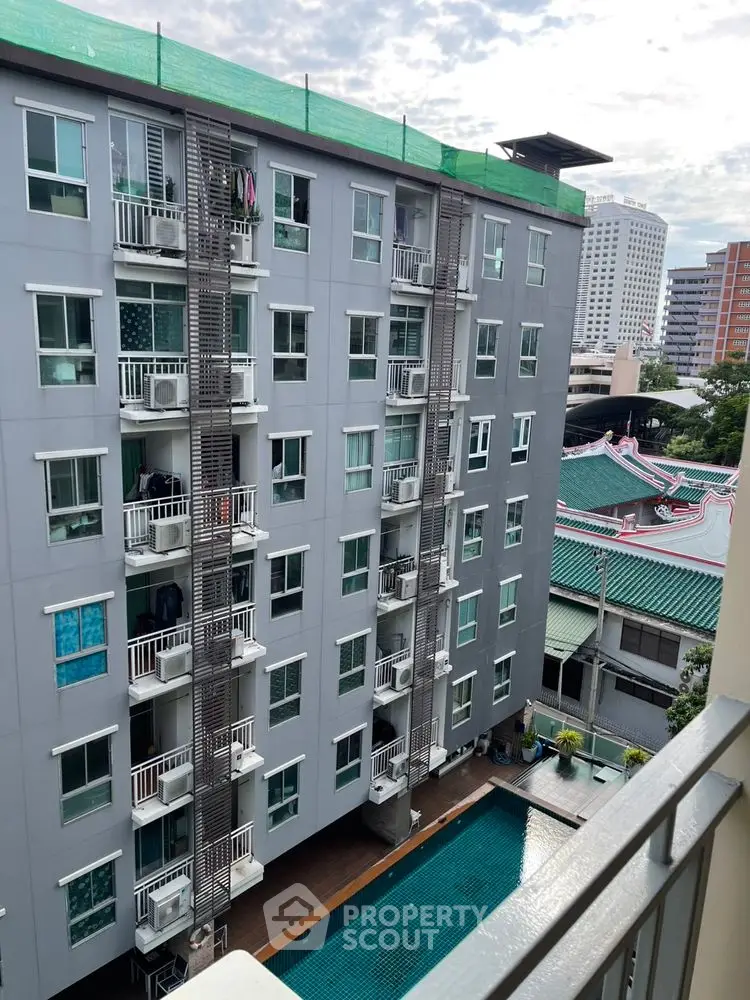 Modern apartment building with pool and city view, ideal urban living.