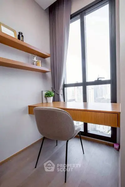 Modern study nook with large window and city view, featuring sleek desk and shelves.