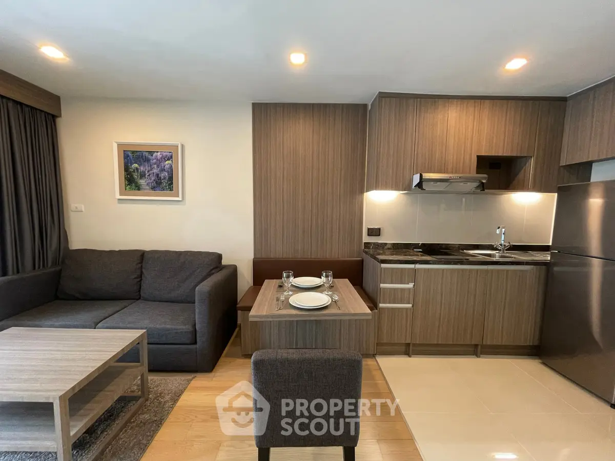 Modern open-plan living room and kitchen with stylish wood finishes and cozy seating area.