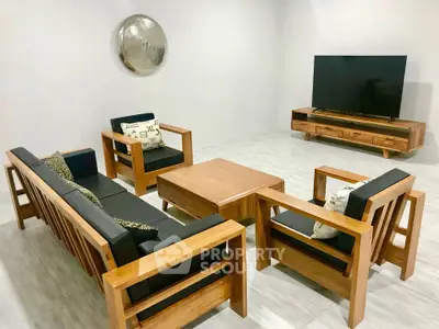 Modern living room with sleek wooden furniture and large flat-screen TV