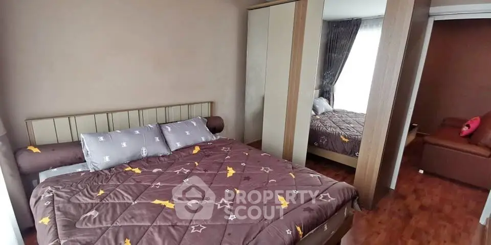 Cozy bedroom with stylish decor and mirrored wardrobe in modern apartment.