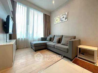 Modern living room with stylish gray sofa and large window, perfect for relaxation.