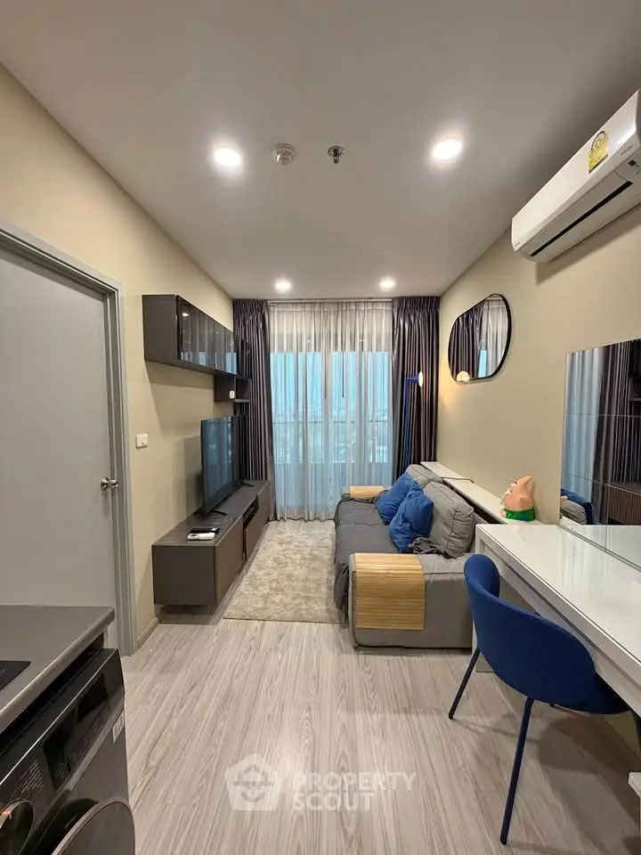 Modern living room with stylish decor, featuring a cozy sofa, wall-mounted TV, and elegant lighting.