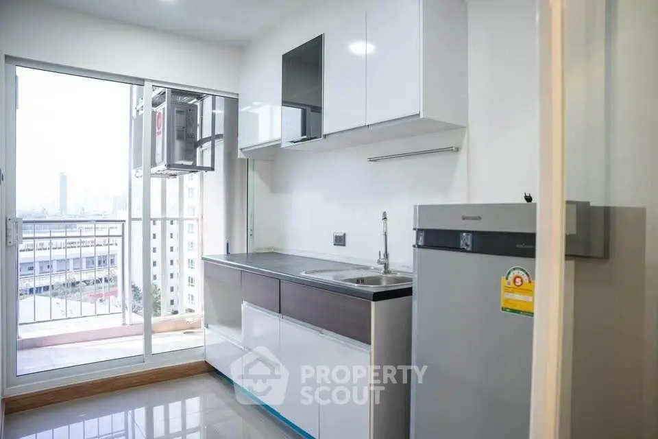 Modern kitchen with sleek cabinets and balcony view in urban apartment