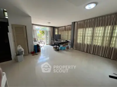 Spacious living room with large windows and natural light, ideal for modern living.