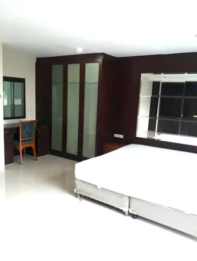 Spacious bedroom with large wardrobe and study desk, ideal for modern living.