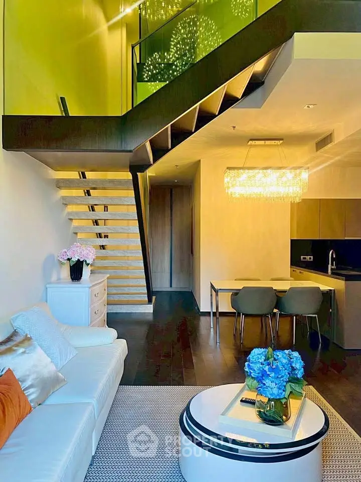 Luxurious modern living room with loft, elegant staircase, and chic dining area in open layout.