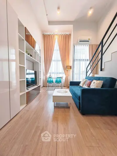 Modern living room with high ceilings, elegant curtains, and stylish furniture in a bright apartment.