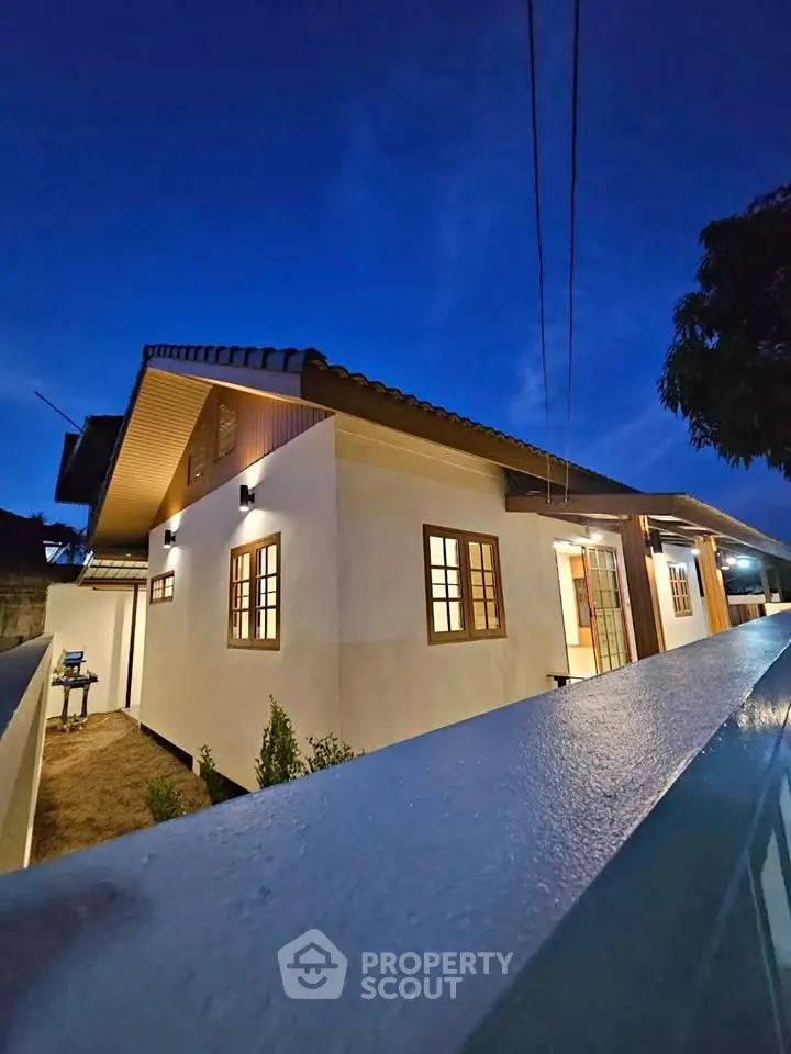 Charming modern house exterior with warm lighting at dusk, showcasing elegant architectural design.