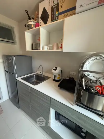 Modern compact kitchen with sleek cabinetry, stainless steel appliances, and efficient storage solutions.
