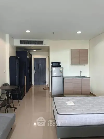 Modern studio apartment with kitchenette and sleek furnishings, ideal for urban living.