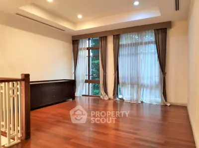 Spacious living room with hardwood floors and large windows for natural light.