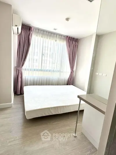 Bright bedroom with large window and modern decor in a stylish apartment.