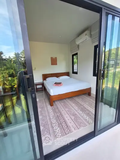 Cozy bedroom with large windows and scenic garden view, featuring a comfortable bed and modern decor.