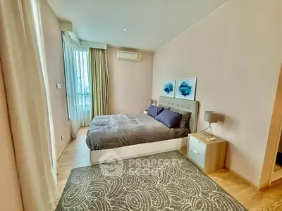 Spacious bedroom with modern decor and large windows in a stylish apartment.