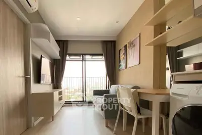 Modern living room with balcony view, stylish furniture, and natural light in a cozy apartment.