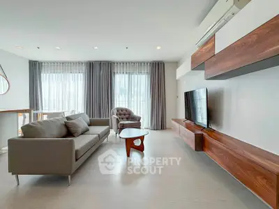 Modern living room with sleek furniture and large windows offering ample natural light.