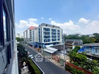 Charming urban street view with modern residential buildings and lush greenery.