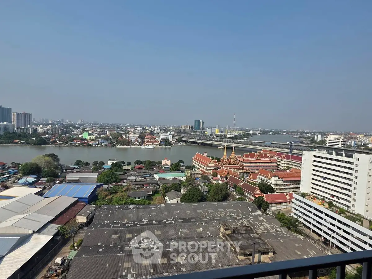Stunning cityscape view from high-rise balcony overlooking river and urban skyline.
