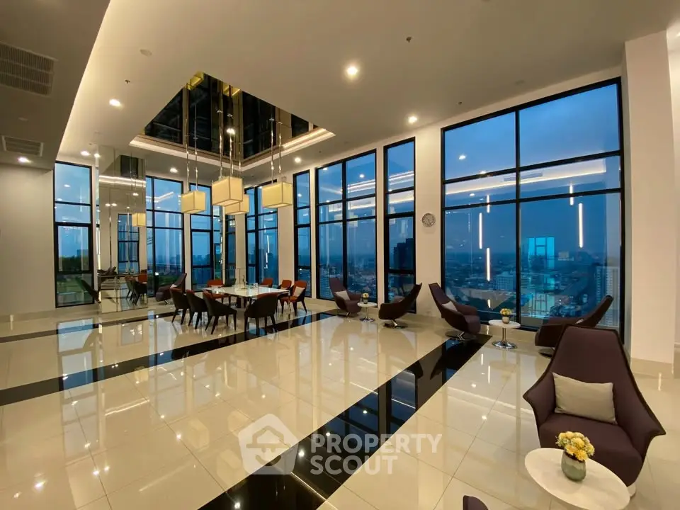 Luxurious high-rise building lobby with panoramic city views and modern seating area.