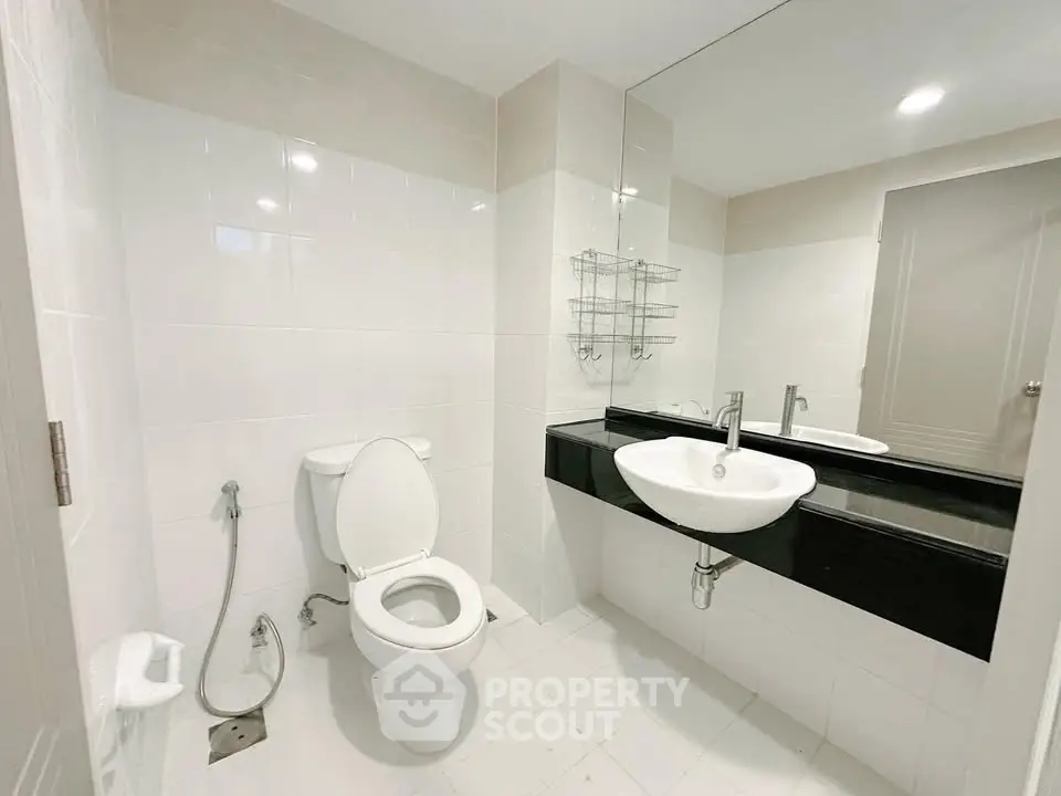 Modern bathroom with sleek fixtures and large mirror in a contemporary apartment.