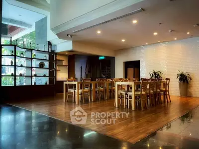 Spacious dining area with elegant wooden flooring and modern decor, perfect for gatherings.