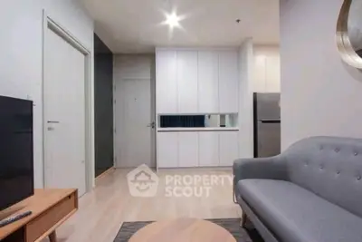 Modern living room with sleek furniture and open kitchen layout in a stylish apartment.