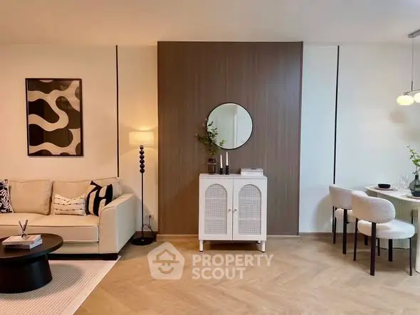 Modern living room with stylish decor and dining area, featuring elegant furniture and warm lighting.