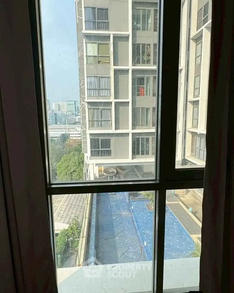 High-rise apartment view with pool and cityscape
