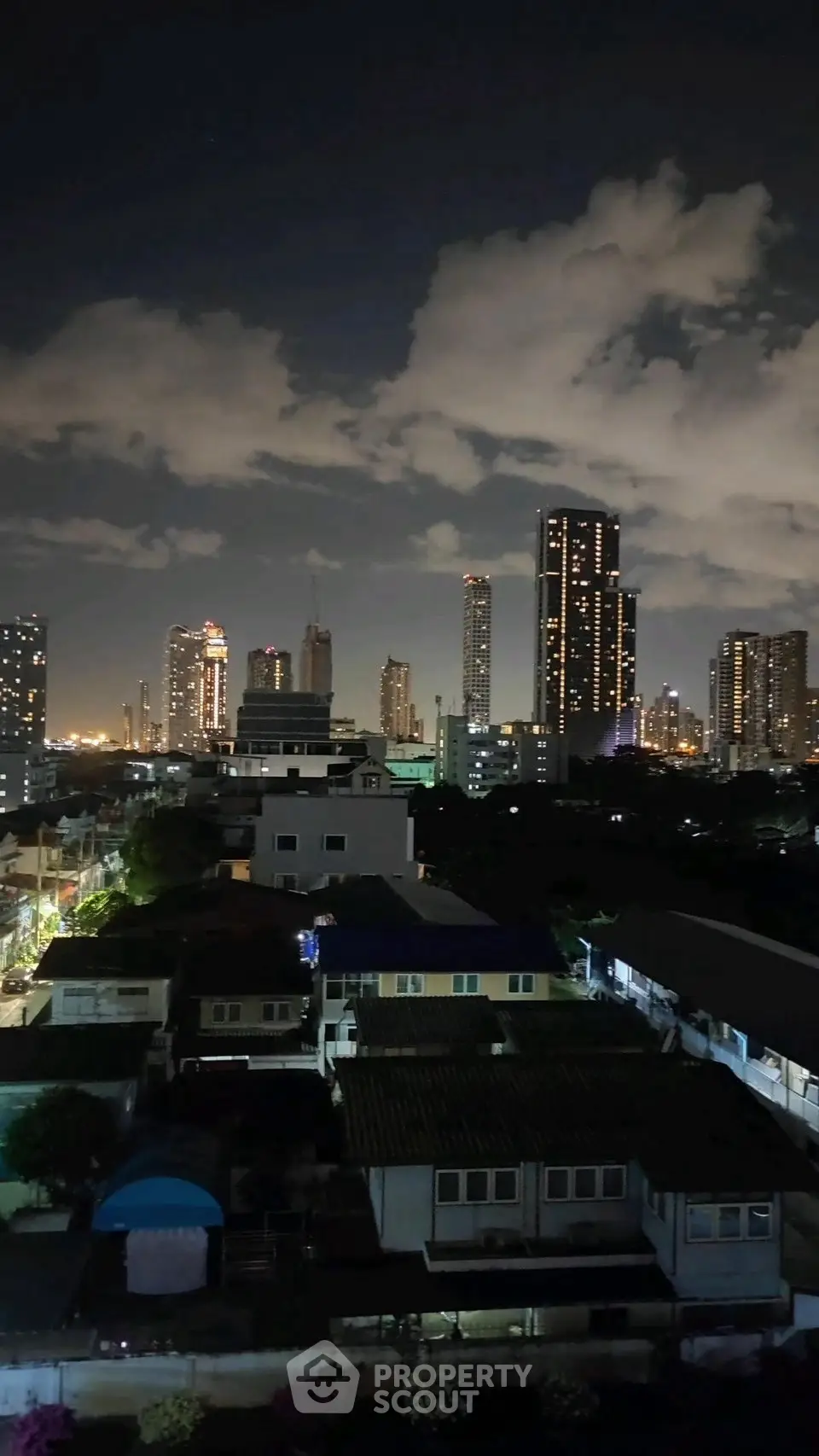 Stunning city skyline view at night with illuminated skyscrapers and residential buildings.