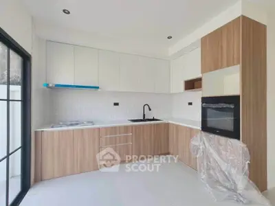 Modern kitchen with sleek cabinetry and built-in oven in a bright, minimalist design.