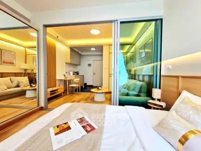 Modern bedroom with open layout to living area, featuring stylish decor and cozy ambiance.