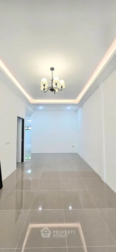 Spacious modern living room with elegant chandelier and glossy tiled flooring