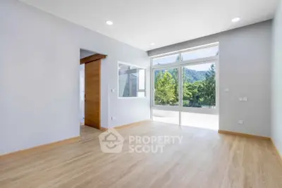 Spacious modern living room with large windows and scenic view, perfect for natural light lovers.