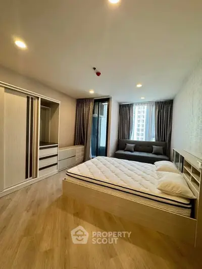 Spacious modern bedroom with large windows and stylish furnishings in a high-rise apartment.