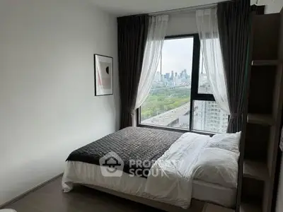 Modern bedroom with city view and large window, featuring stylish decor and cozy bedding.