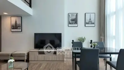 Modern living room with high ceilings, stylish decor, and large windows for natural light.