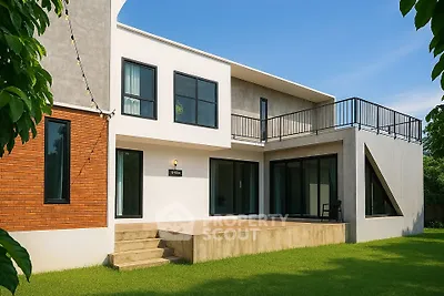 Modern two-story house with spacious balcony and lush green lawn