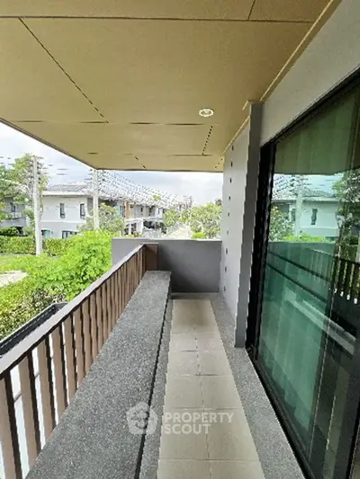 Spacious balcony with modern railing and garden view in a contemporary home.