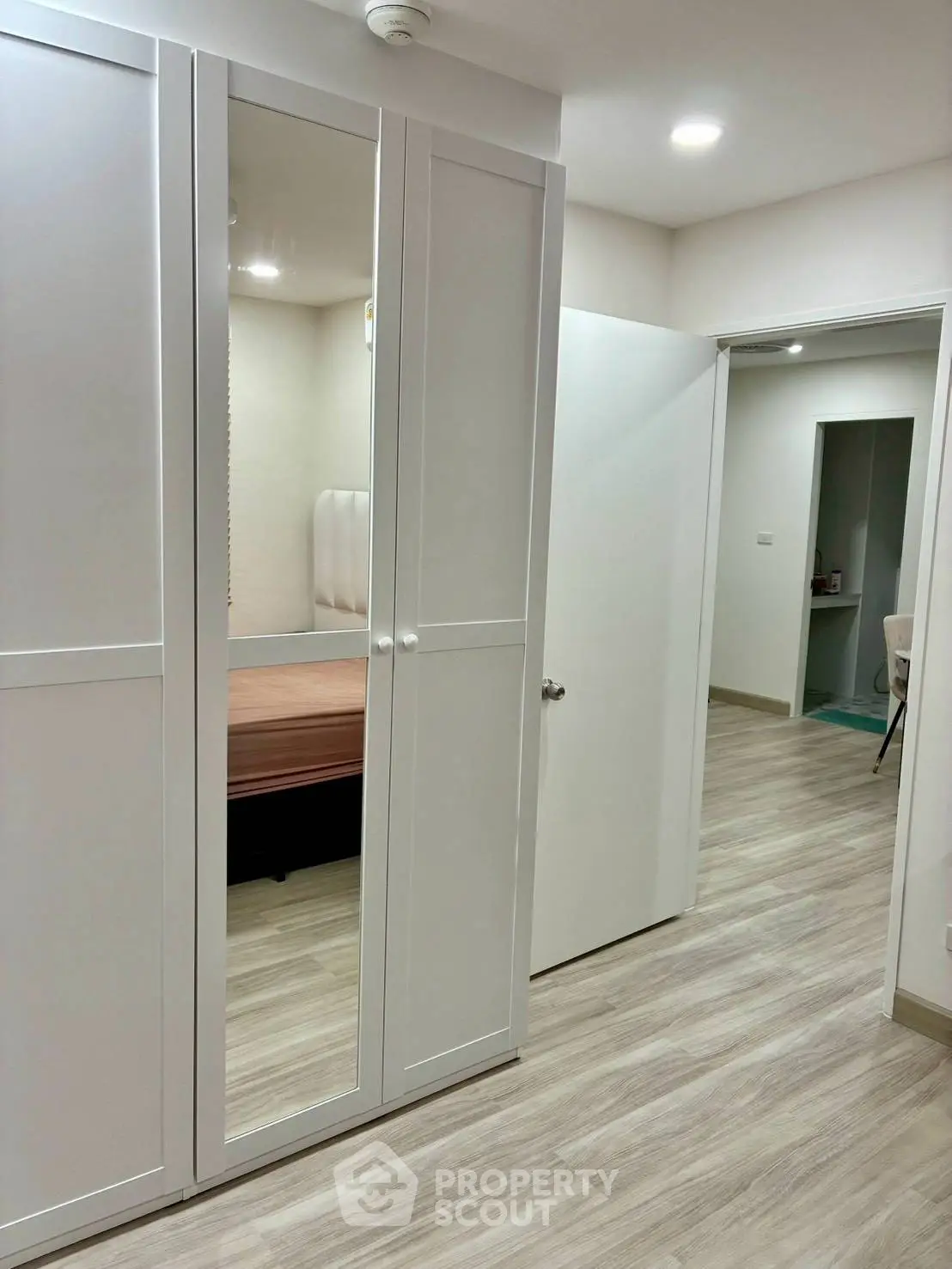 Modern apartment hallway with sleek wardrobe and wooden flooring